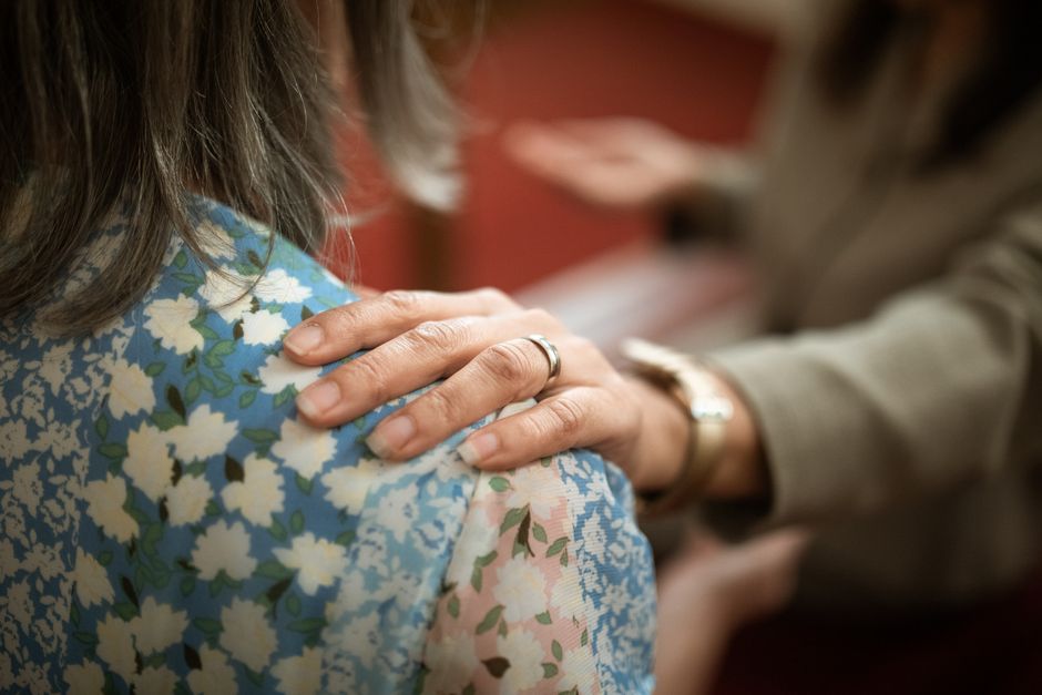 Main posée avec soin sur une épaule, évoquant l'appui de la corégulation
