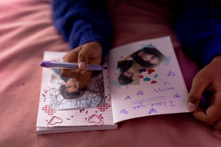 Personne écrivant dans un journal intime entouré de photographies anciennes
