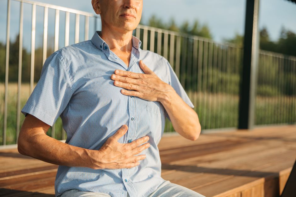 Personne pratiquant une respiration apaisante, mains posées sur la poitrine et le ventre
