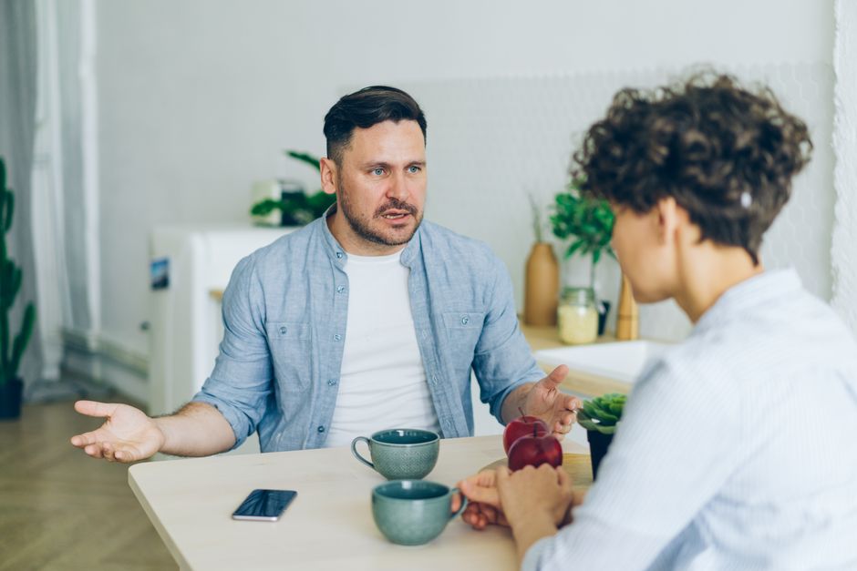 Deux personnes en conversation posée autour d'une table, mettant des mots sur l'expérience